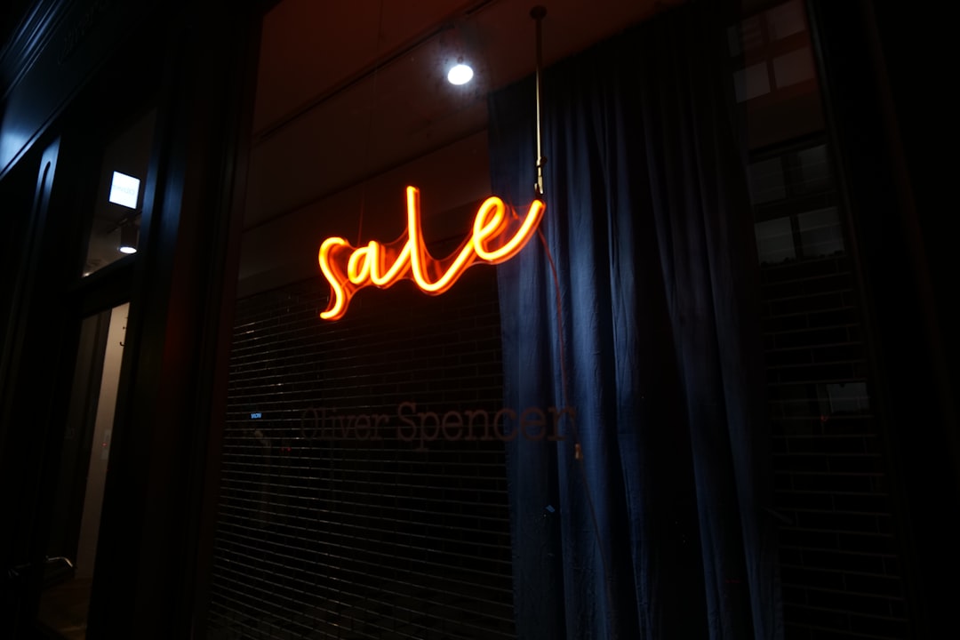 Orange neon sale sign in a dark window